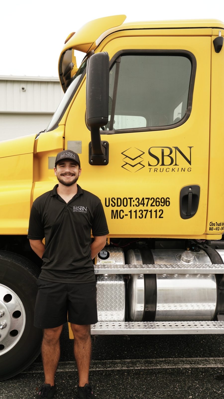 SBN Trucking cab with a team member in front
